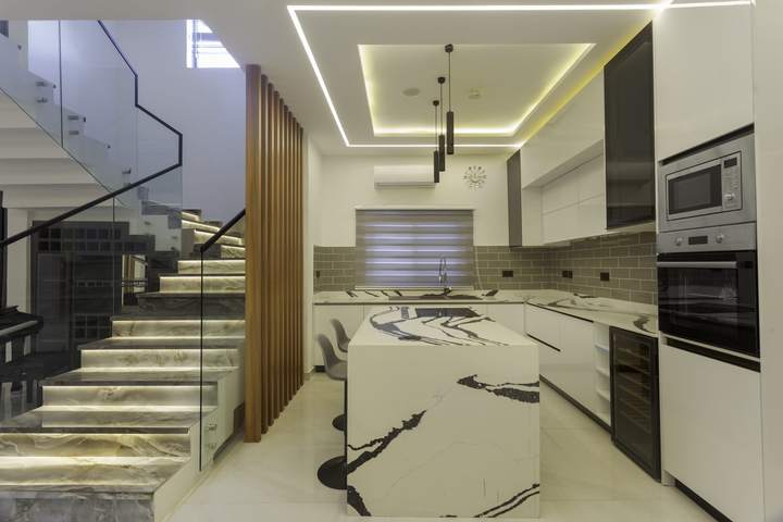 Kitchen beside the lit staircase