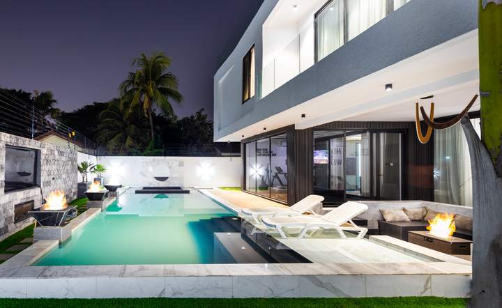 Swimming pool and fire bowls at night